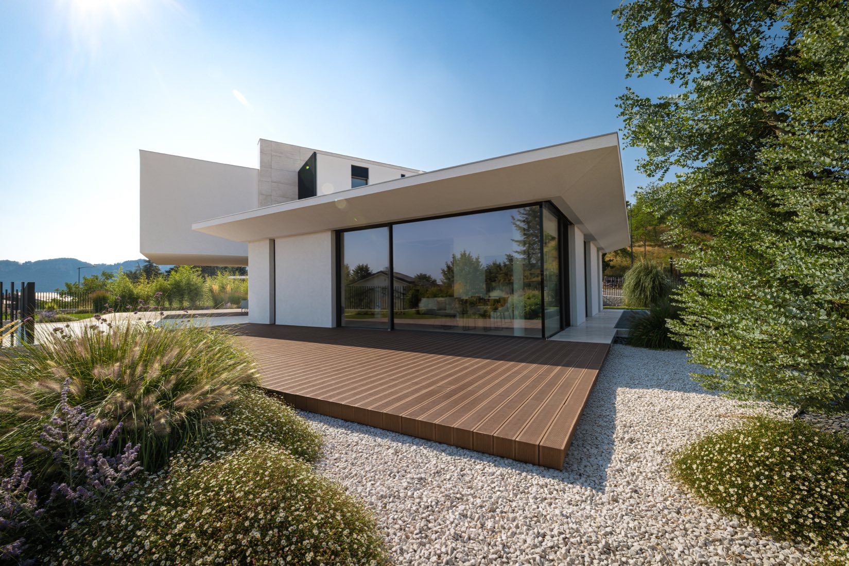 La casa con il deck in legno e il giardino di graminacee