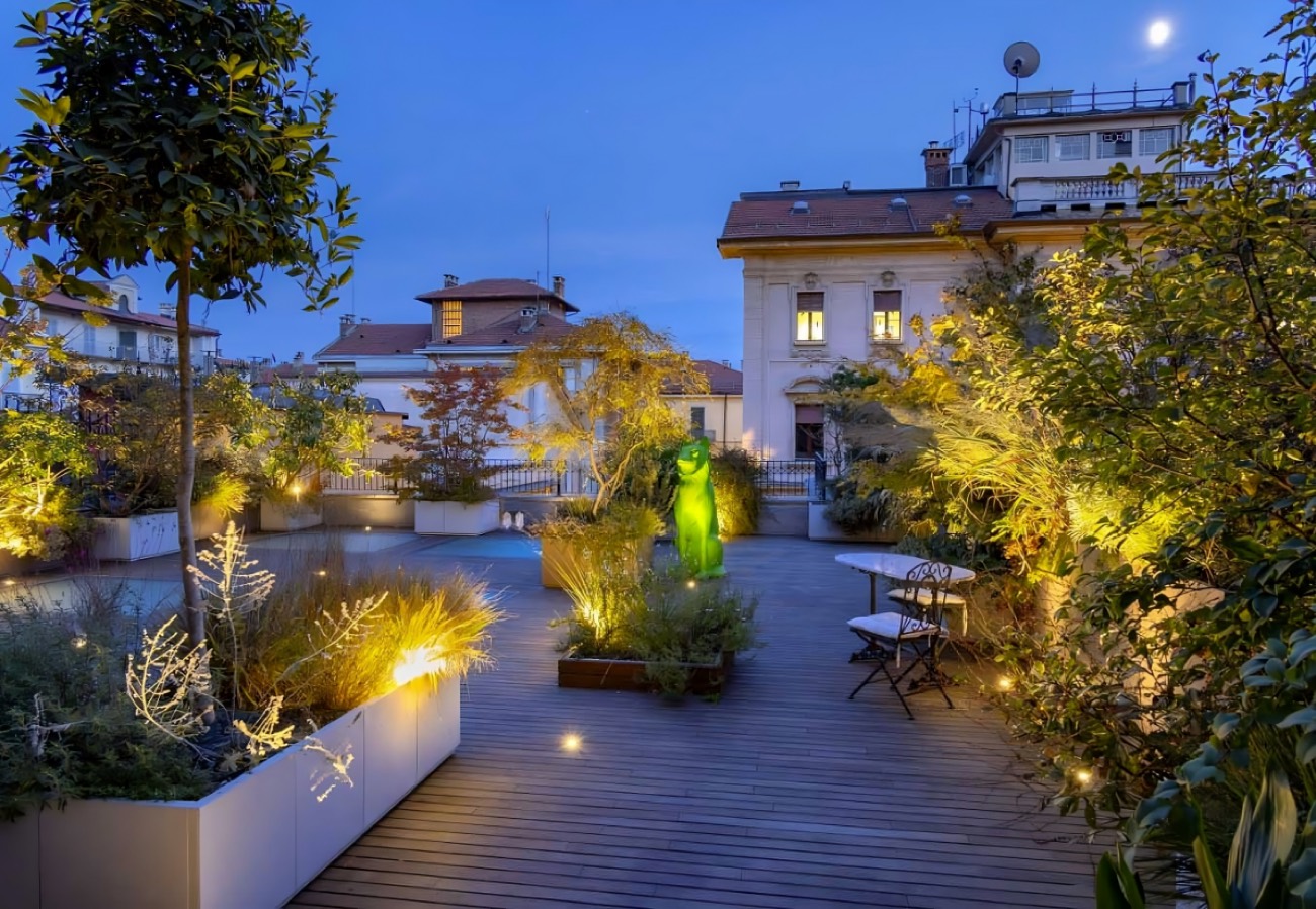 Terrazza illuminata la sera fra le fioriere