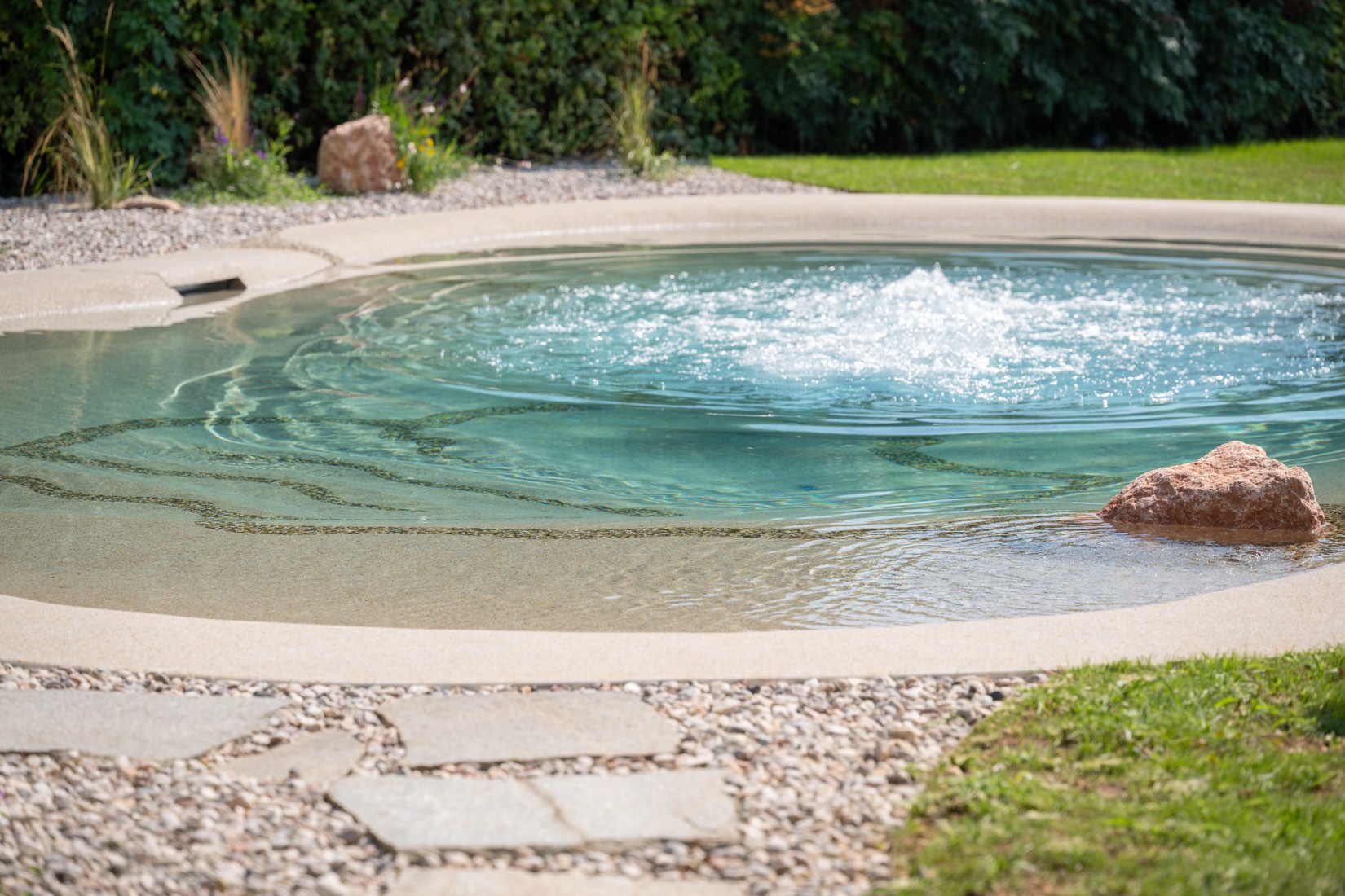 Idromassaggio nella piscina naturale, con il masso sul bordo