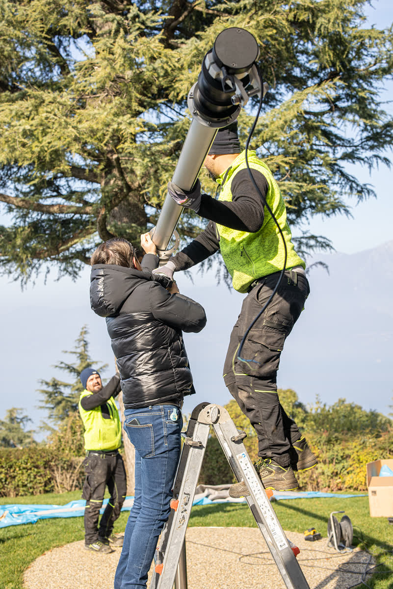Due operatori sulla scala alzano il palo della vela